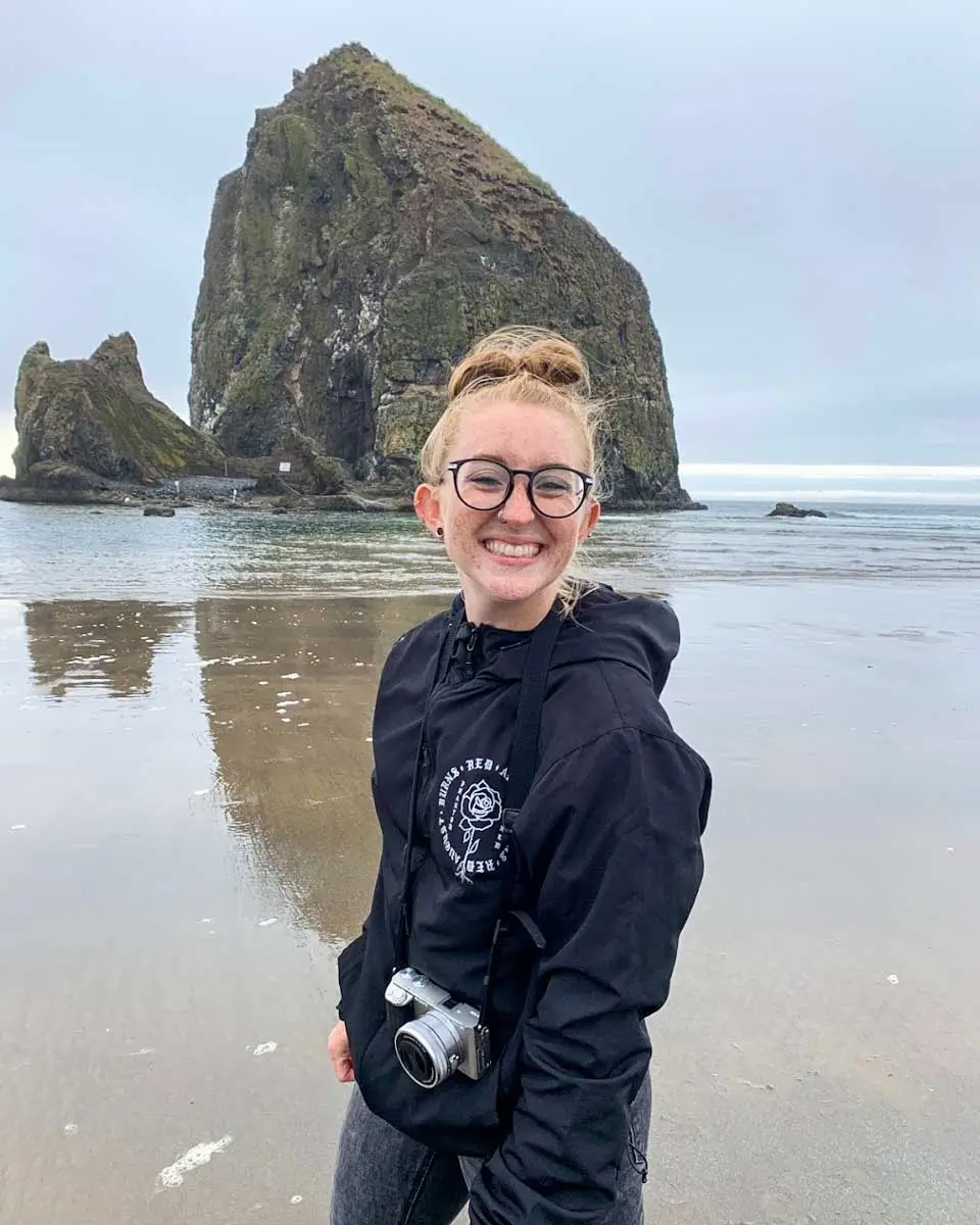 Meghan posing in front of Haystack Rock in Portland, Oregon