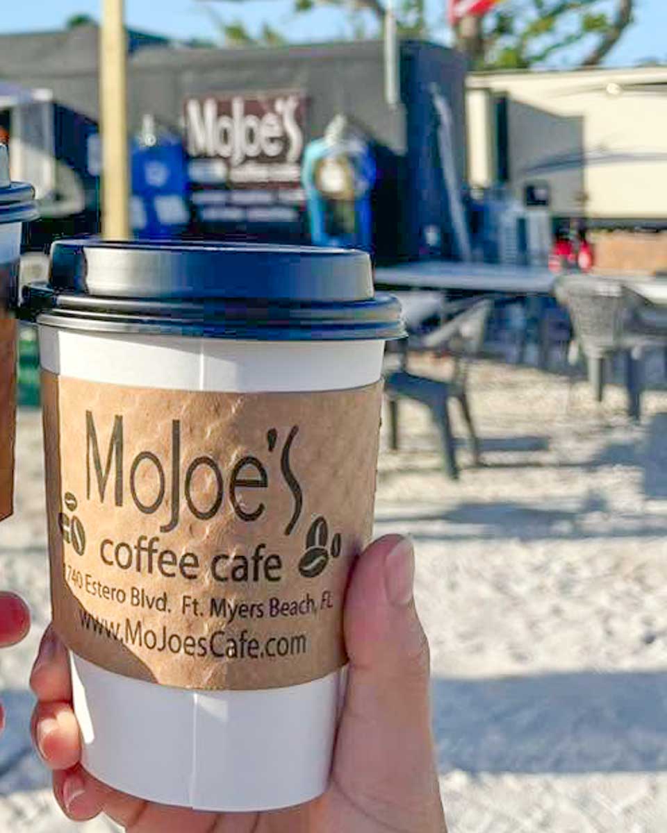 People hold up coffee at MoJoe's Coffee Cafe in Fort Myers Beach