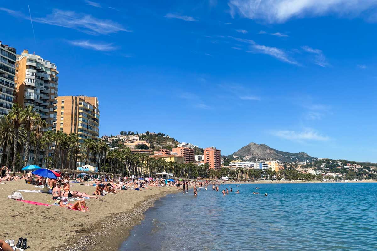 People lounge on Playa La Malagueta in Malaga, spain